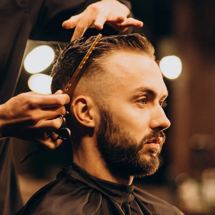 A barber cutting a client's hair at AP's Barbers