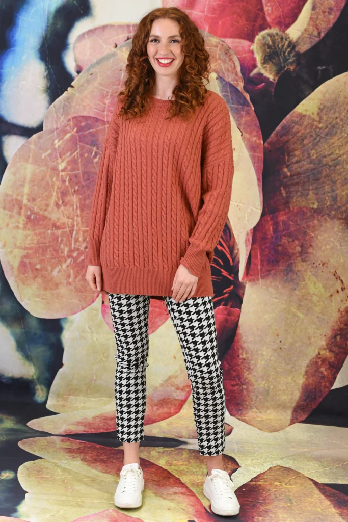 A woman wearing a jumper and black and white pants
